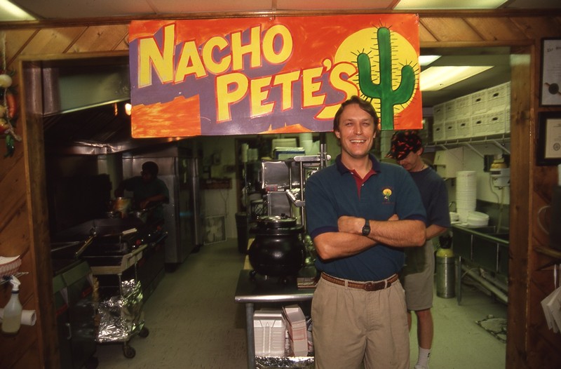 Man standing in front of Nacho Pete's sign