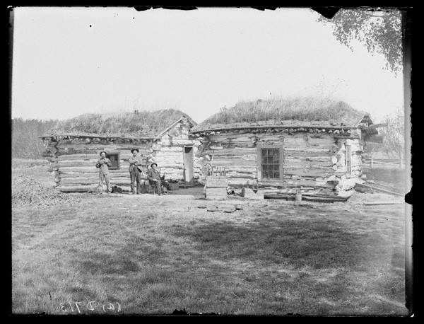 C.R. Mathews, seated. Oscar Smith, left. George Carr, right. In front of Mathews cabins.