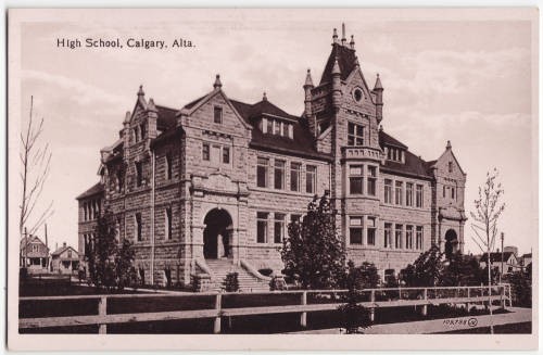 “Postcard. Black and white photograph of Central High School in Calgary. A fence can be seen lining the front entrance and two houses are visible on the left hand side. Red text on front (top): ’High School, Calgary, Alta.’” pc_164