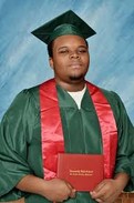 This photo taken of Michael Brown Jr. depicts him in his graduation cap and gown. This photo was chosen to put on his permanent plaque. It depicts his strength and dignity through his education and his hopes for the future.