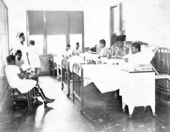 This 1947 photo shows several girls & nurses in the children's ward at Brewster Hospital, a well-remembered African American facility. The girl sitting to the left wears a brace on her leg.