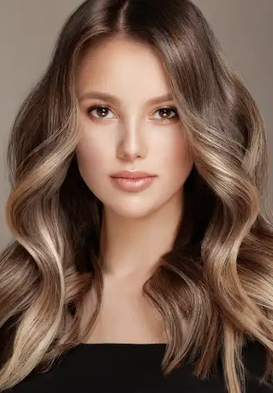 Woman with long, voluminous hair styled in soft waves, creating an elegant look