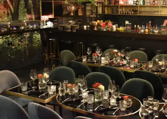 Eleganter Innenbereich des Cafés mit gedeckten Tischen, Gläsern und Bar – Eventlocation im Herz von Frankfurt.
