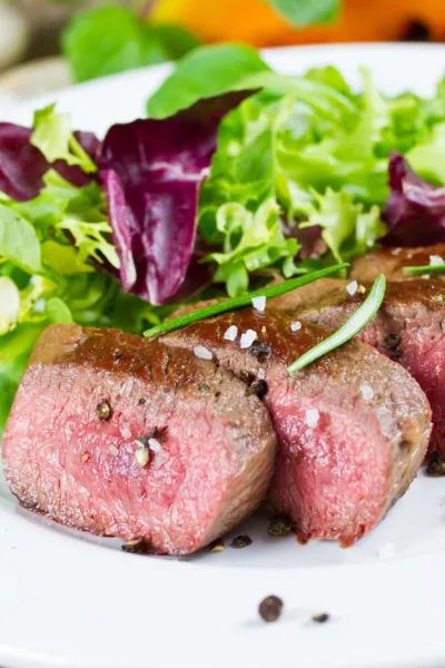 Zartes HĂŒftsteak, medium gebraten und serviert mit Salat â ideal fĂŒr bewusste Steakliebhaber Medium gegrilltes HĂŒftsteak mit frischem Salat und Rosmarin angerichtet â saftig, zart und perfekt gebraten