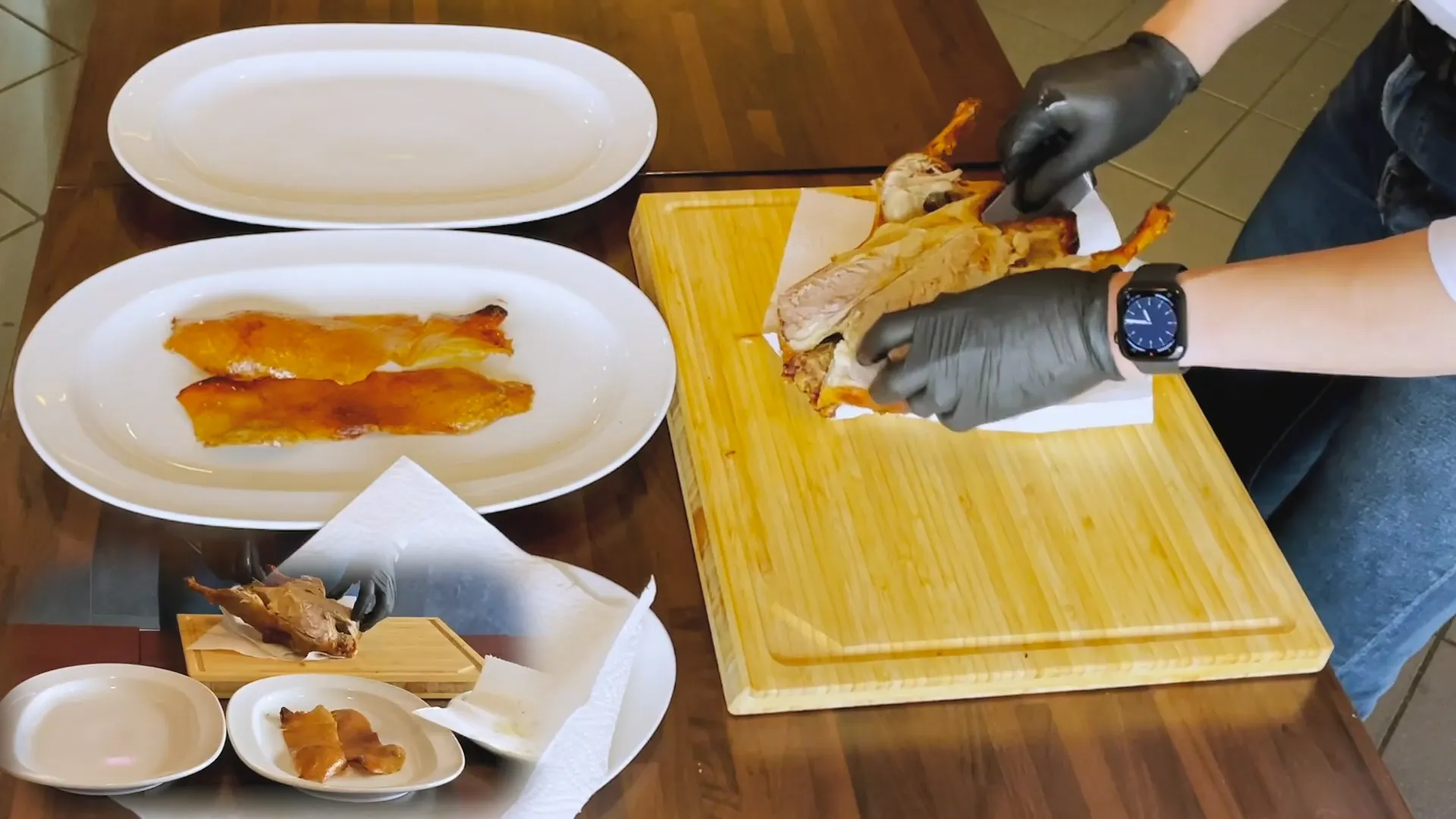 Peking Ente tranchieren Step 5 - Drehe die Peking-Ente um und setze das Messer mittig an, um einen Schnitt zu machen. Führt die Messerspitze an der offenen Brustseite und schneidet behutsam zwischen der Haut und das Fleisch. Lasse das Messer entlang der Hautseite gleiten und löse die knusprige Haut ab, indem du das Messer vorsichtig zwischen die Haut und das Fleisch schiebst. Ziehe das Messer entlang des Schnittes in Richtung Kopf und versuche, die knusprige Haut als ein ganzes Stück zu tranchieren.