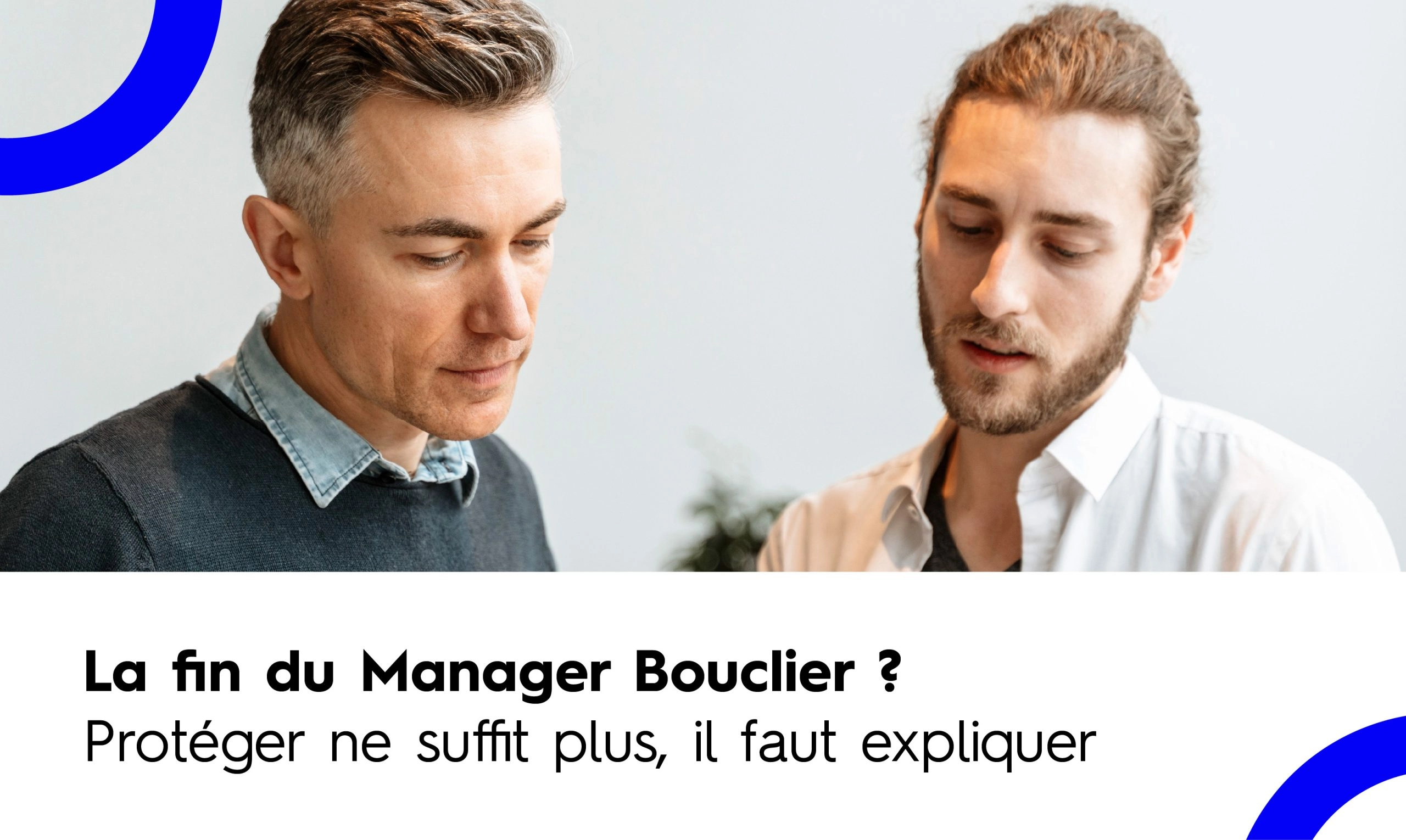 Deux hommes en discussion professionnelle, l'un plus âgé et l'autre plus jeune, regardant vers le bas avec sérieux. Le texte en superposition indique : "La fin du Manager Bouclier ? Protéger ne suffit plus, il faut expliquer".