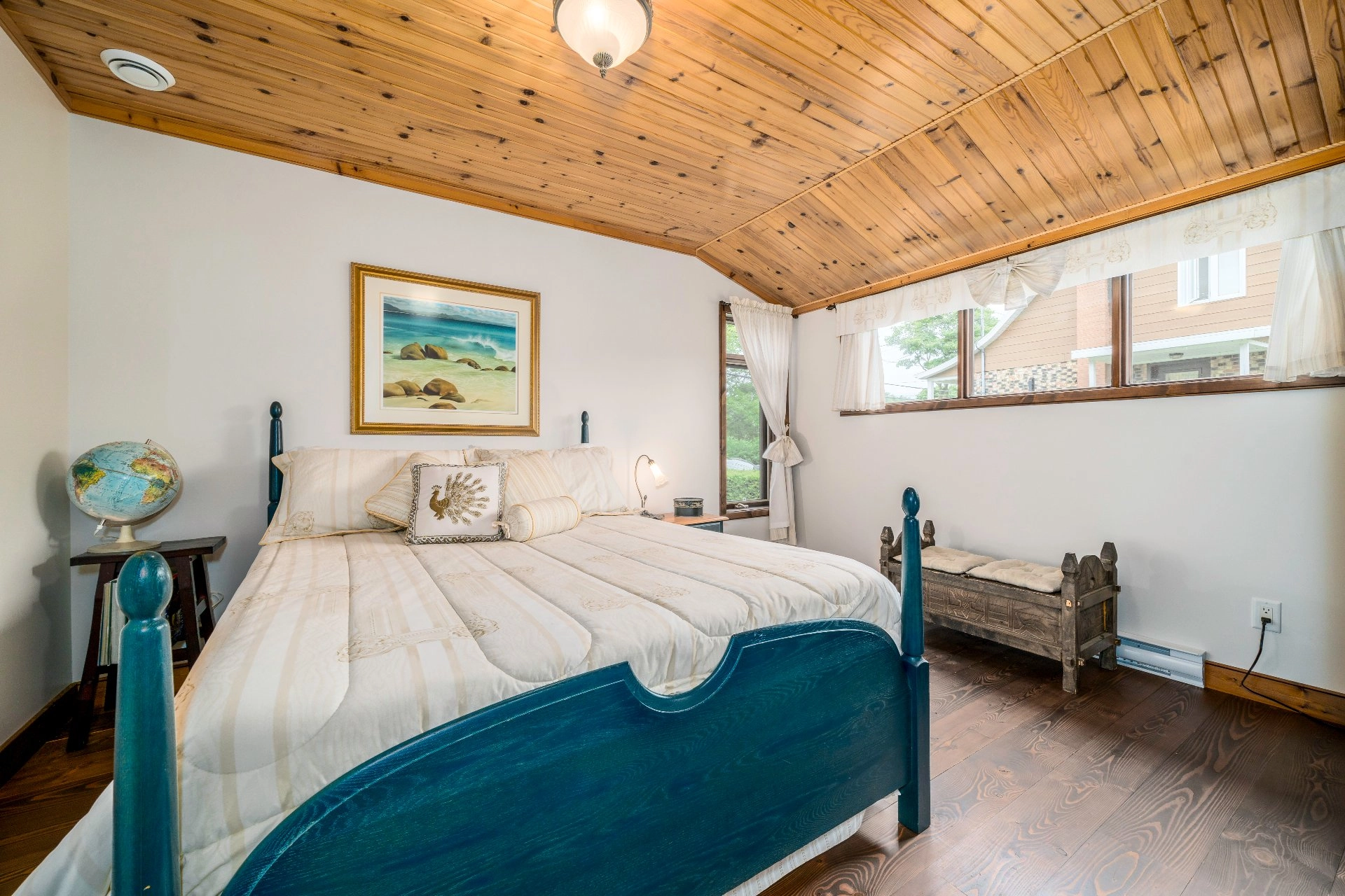 Chambre spacieuse avec plafond en bois.