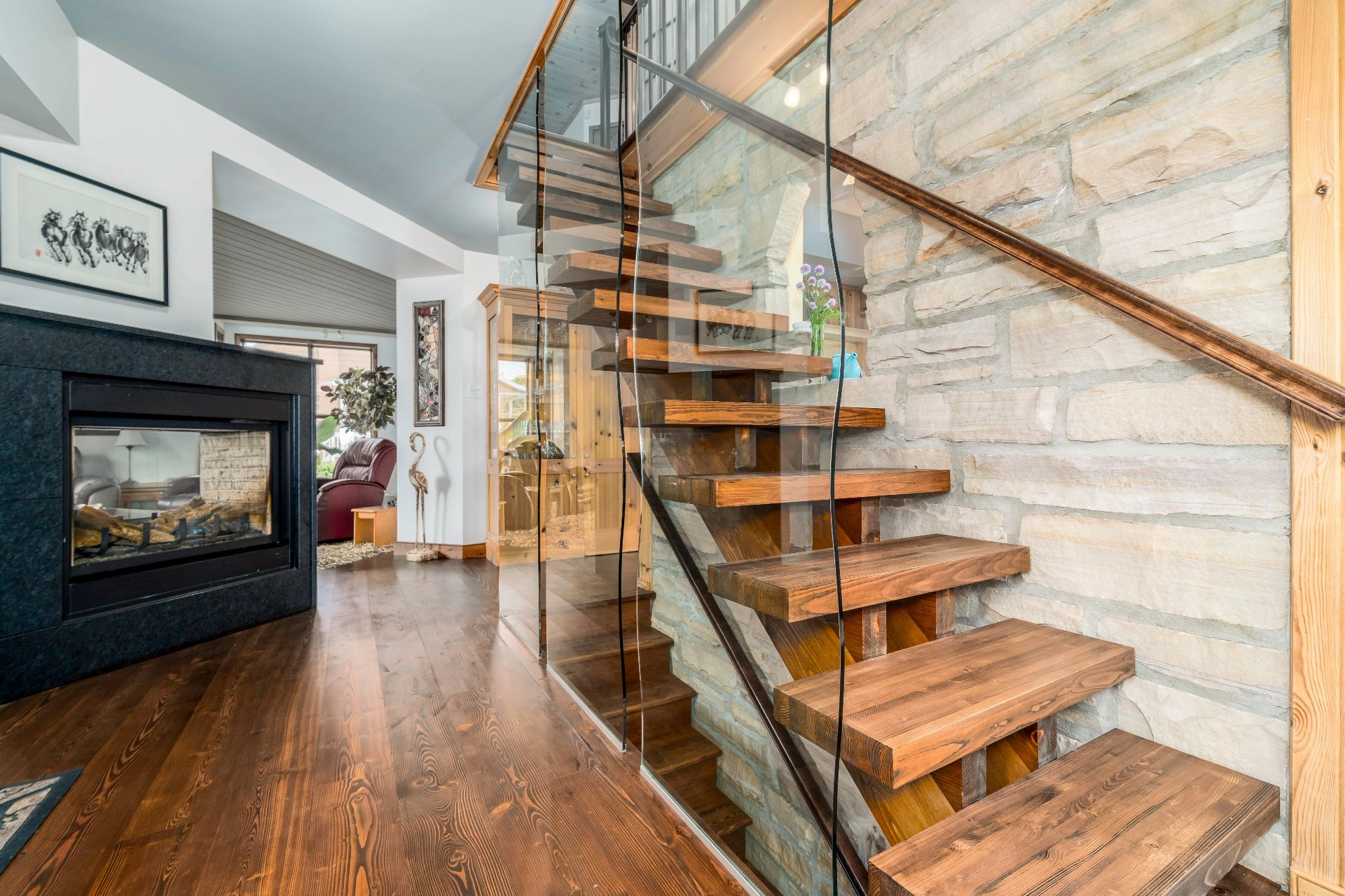 Escalier moderne en bois avec rambardes en verre.