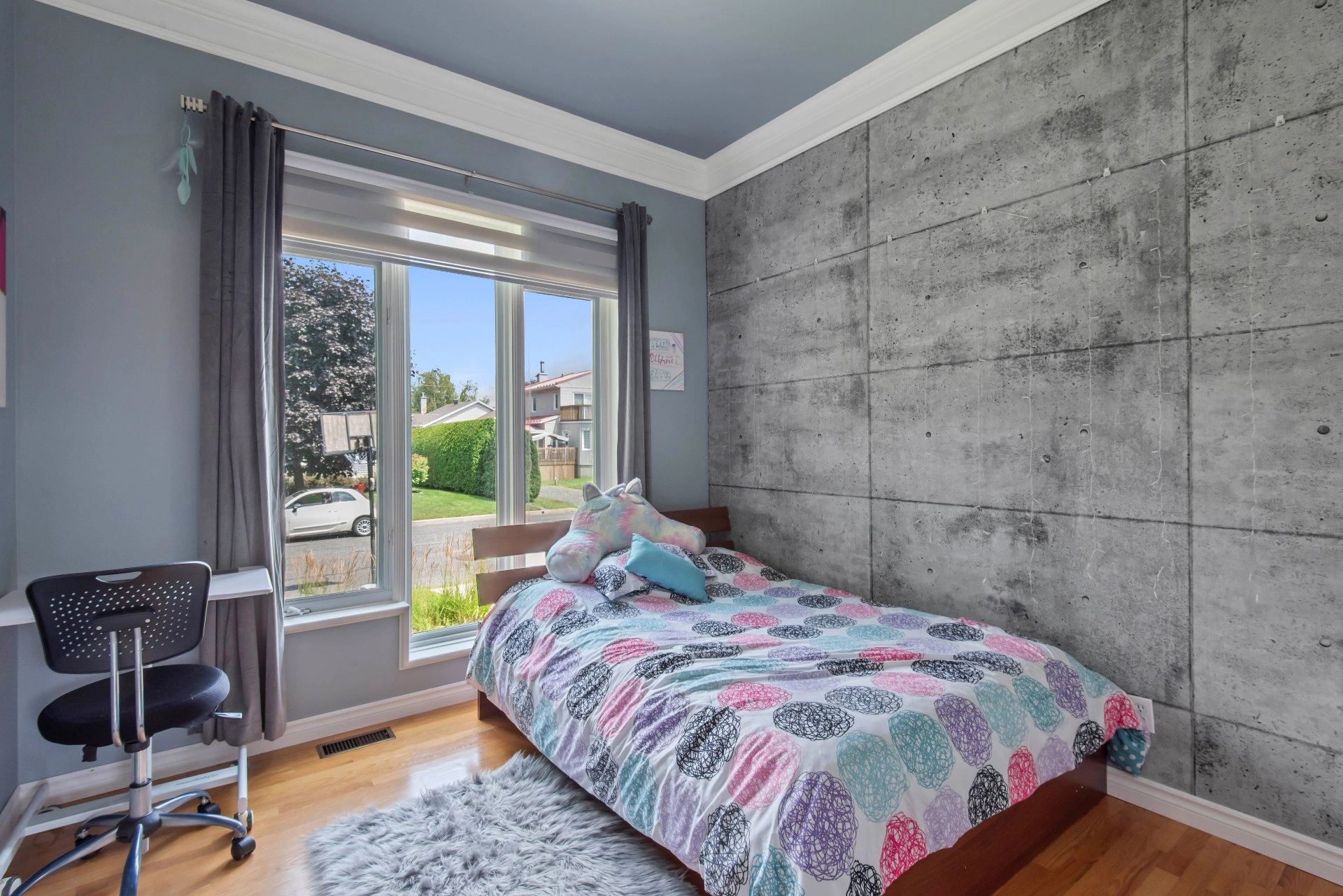 Chambre lumineuse avec grande fenêtre et parquet en bois