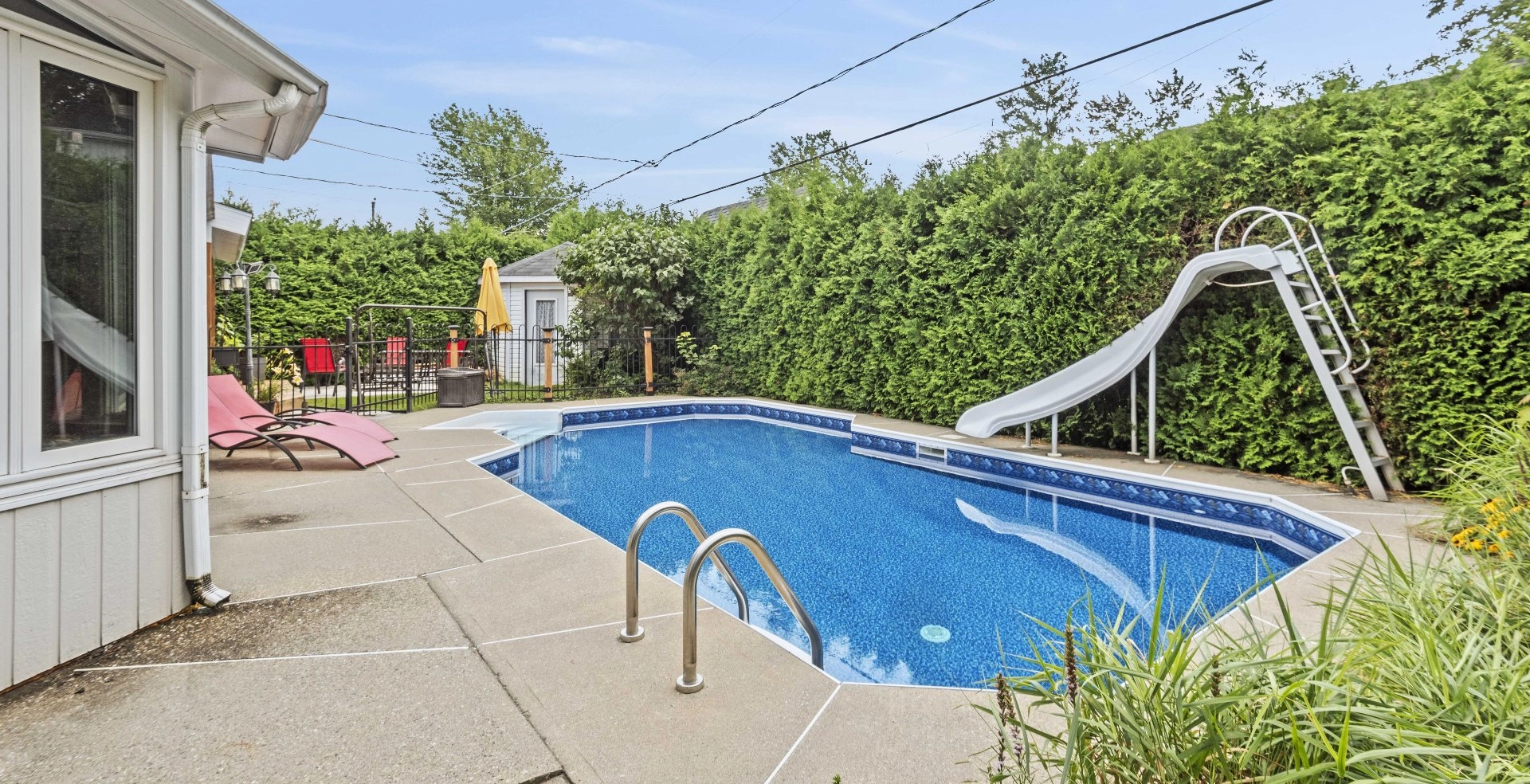 Piscine extérieure entourée par une haie dense