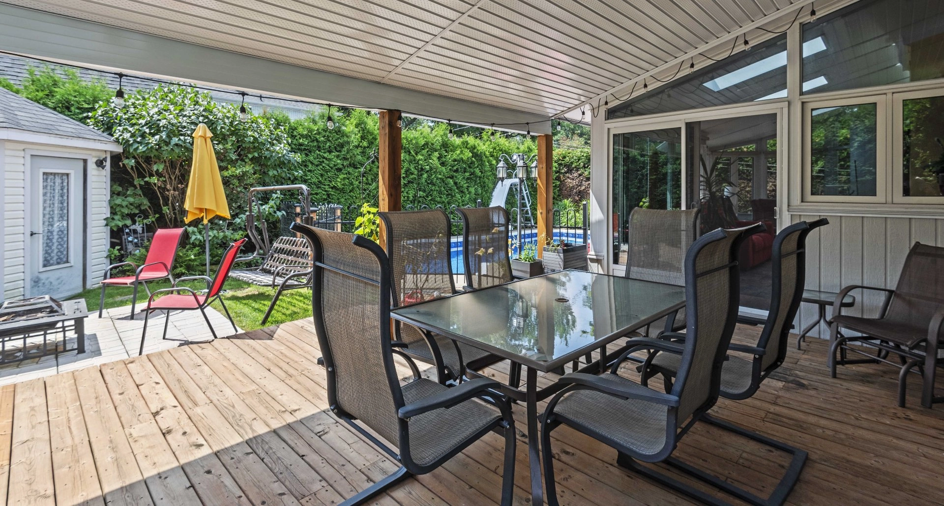 Terrasse couverte avec vue sur le jardin et la piscine