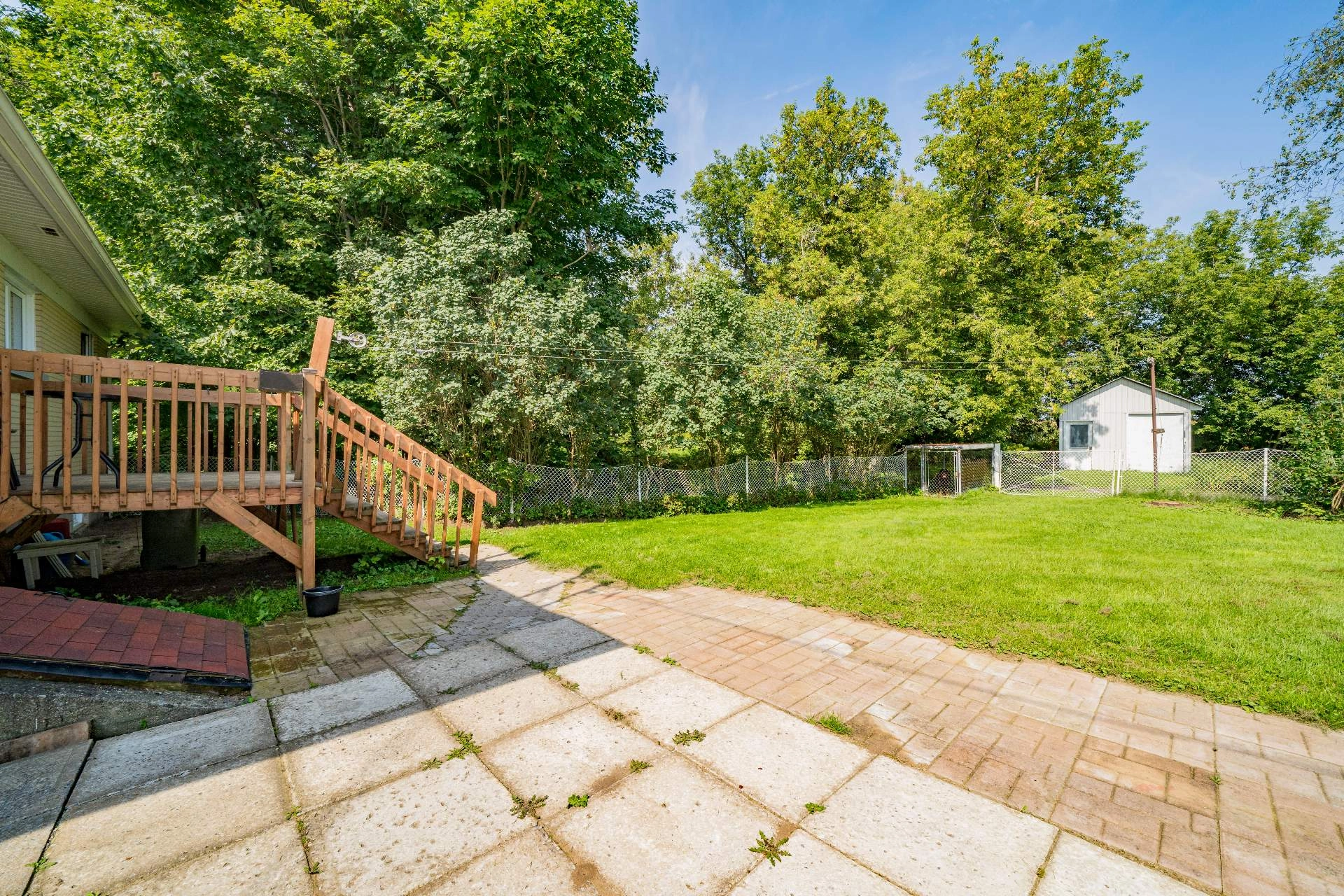 Espace extérieur de la maison avec terrasse en bois et dépendance.