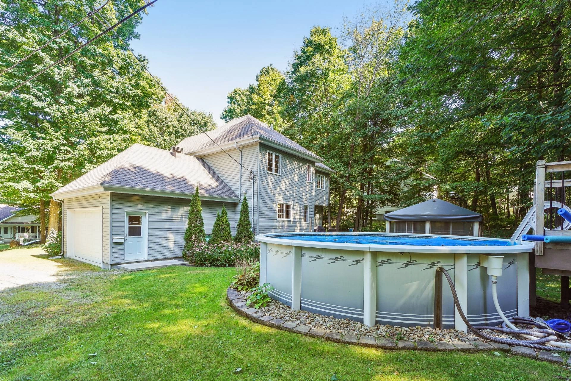 Single-story outbuilding with mature trees and natural light