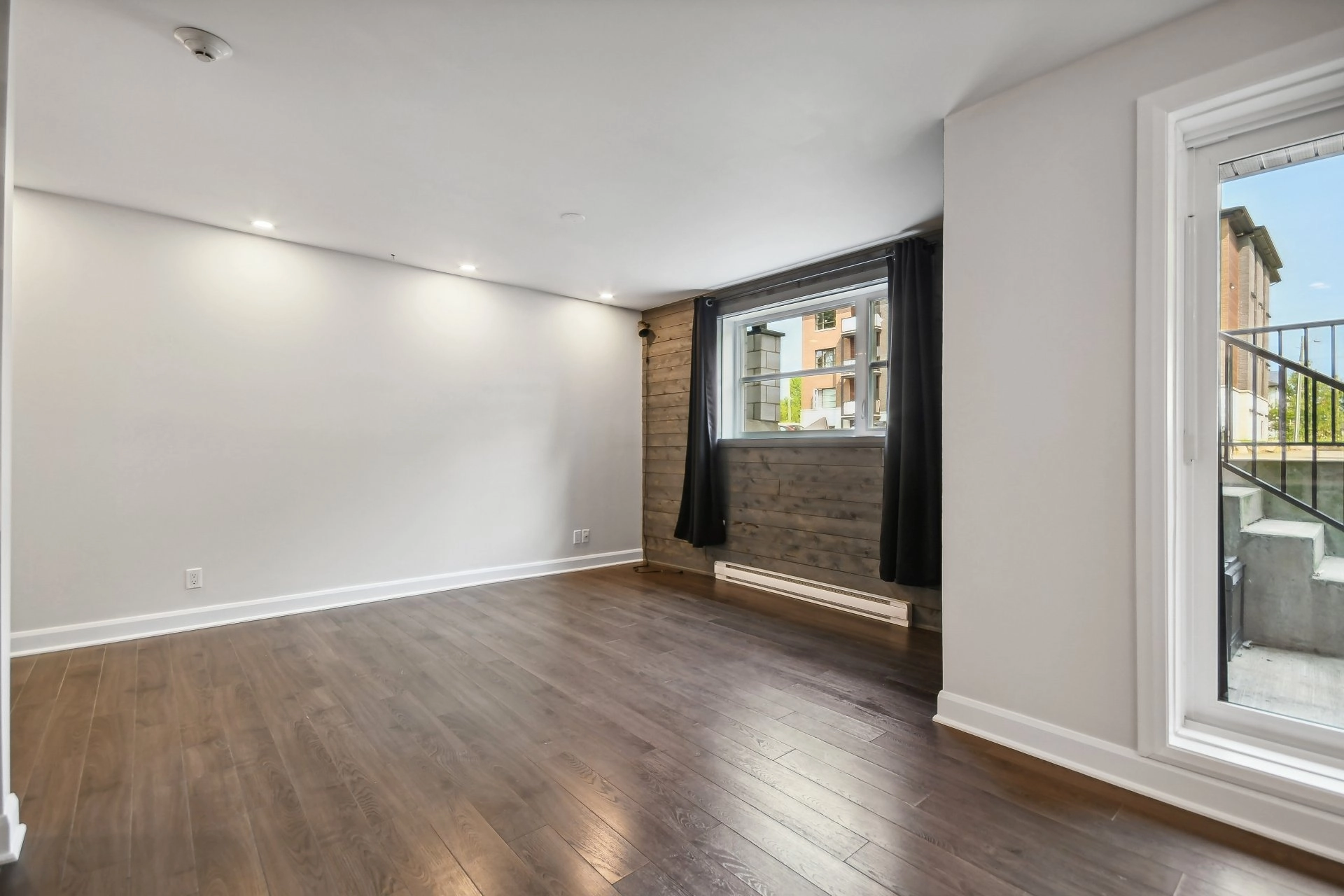 Parquet en bois sombre et grande porte-fenêtre