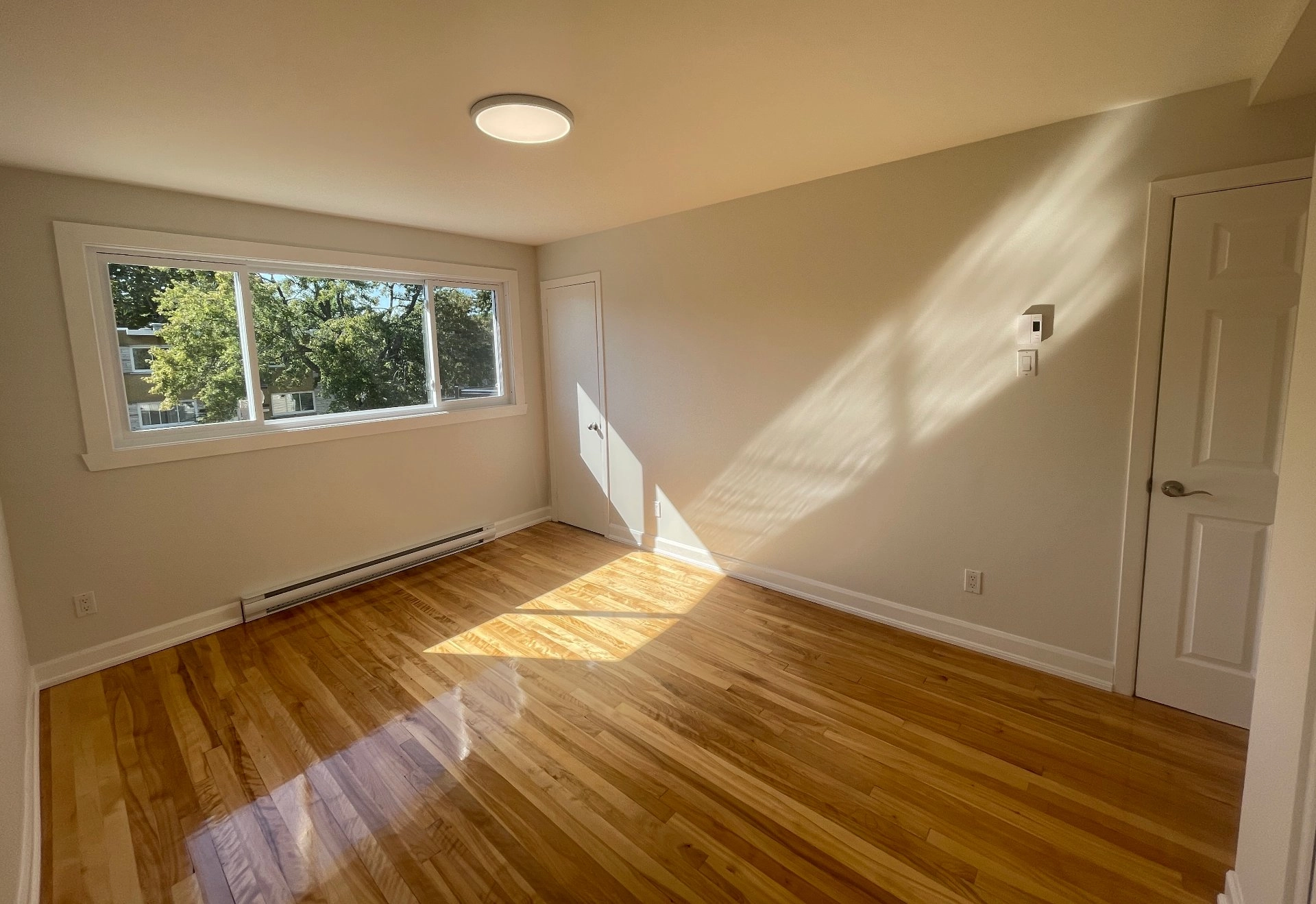 Chambre lumineuse avec grande fenêtre