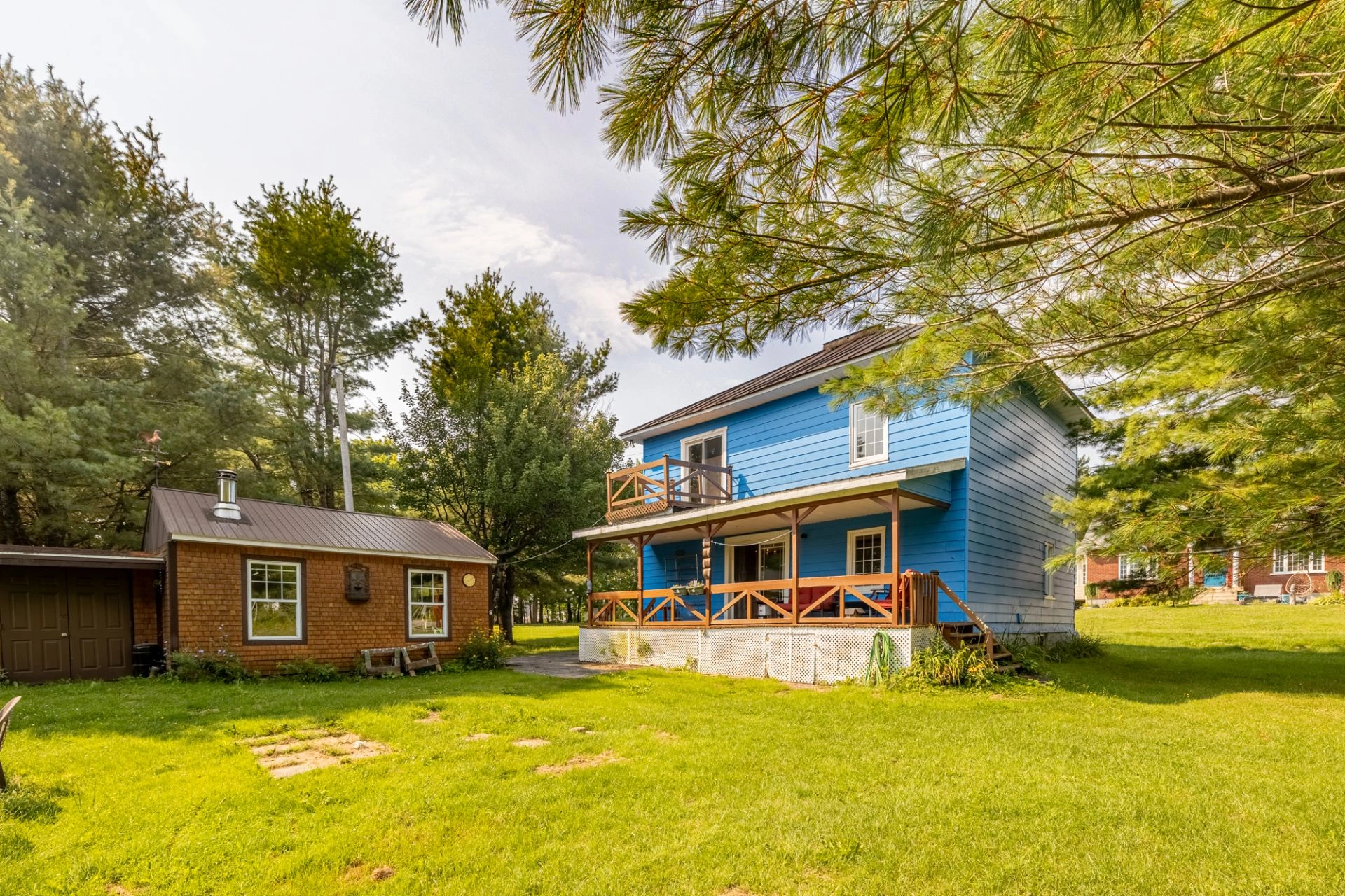 Maison bleue avec pelouse spacieuse et arbres matures