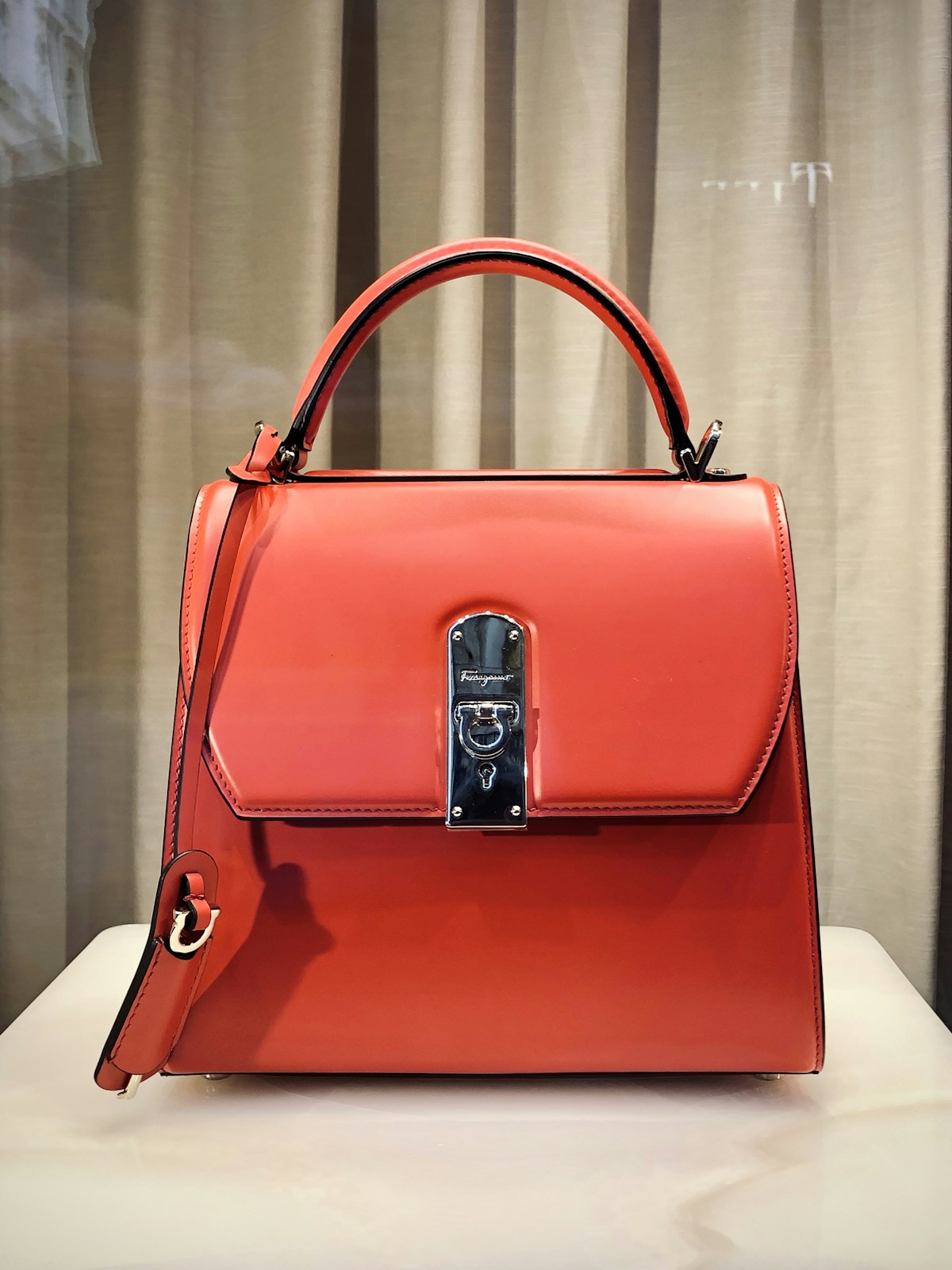 Sculptural cream-colored vegan leather handbag styled on a marble surface with soft natural light