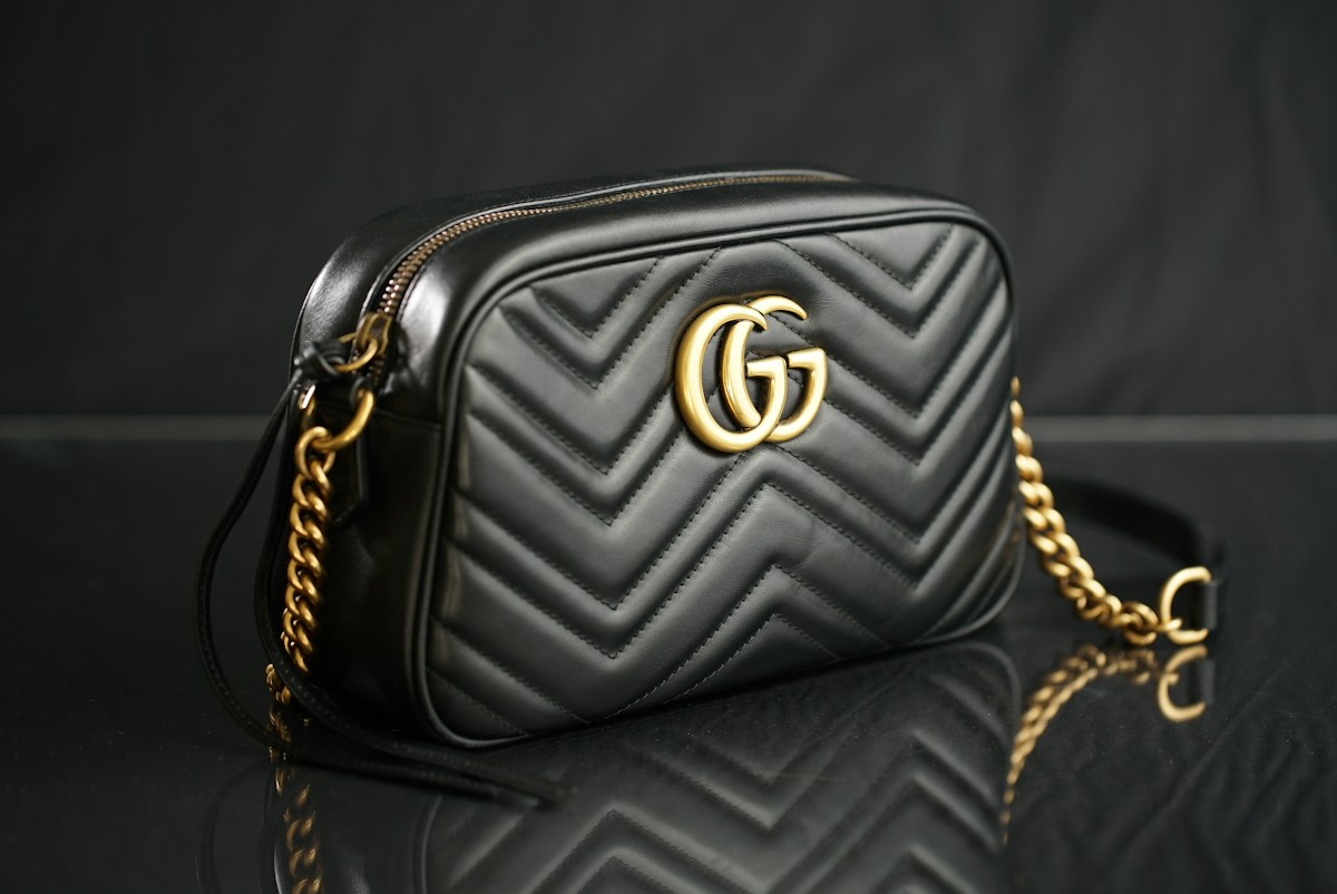 Person confidently walking down a city street carrying a stylish structured handbag