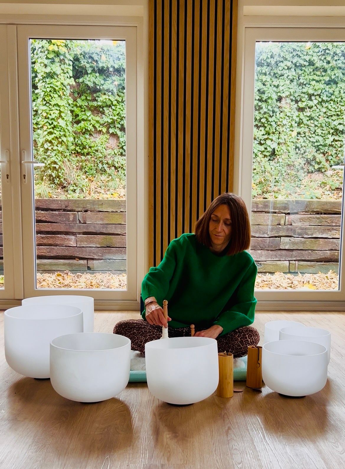 female playing crystal sound bowl soundbath