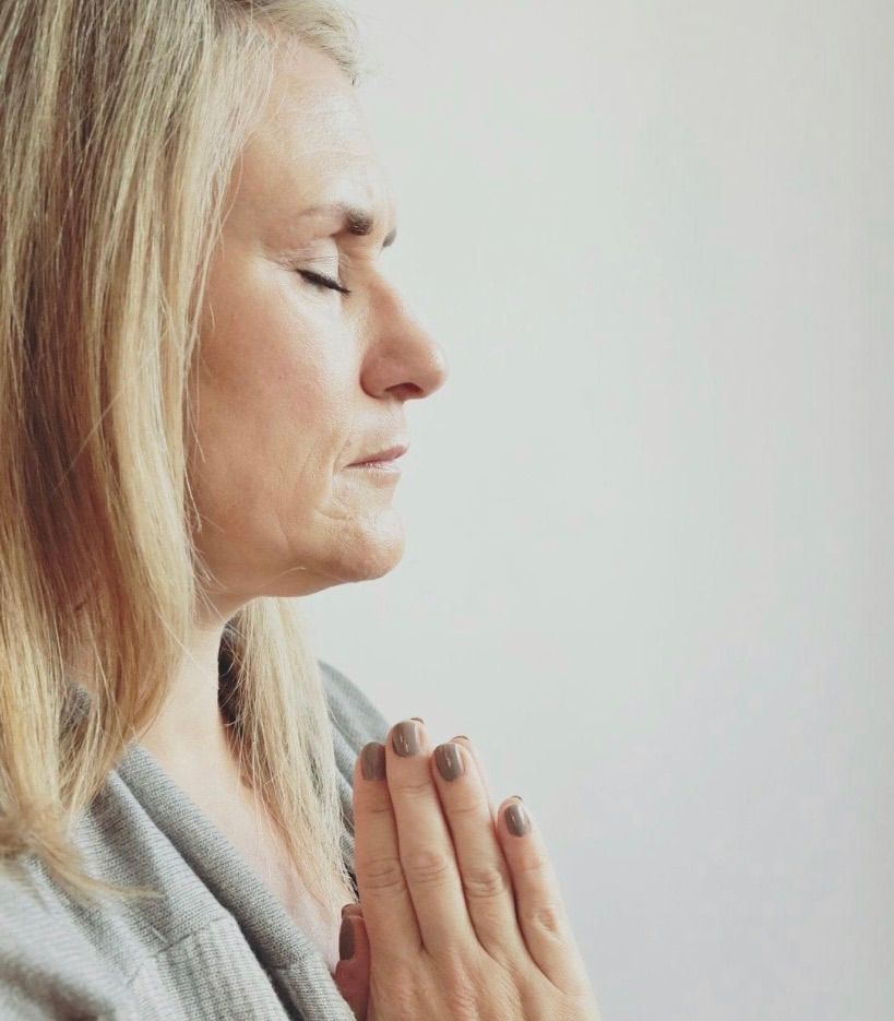 Person sitting in meditation, eyes closed, in a peaceful and mindful state.