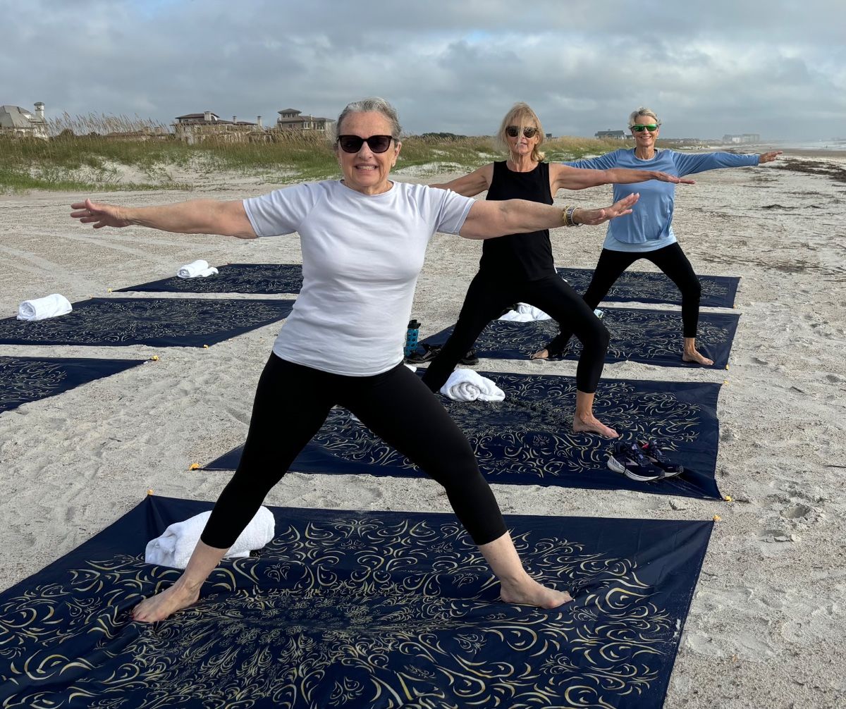 Women in tree pose on the beach