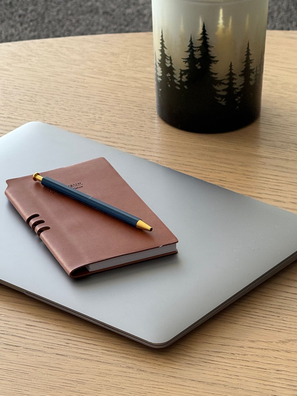 Organized desk setup with a sleek leather notebook and pen, representing optimized booking software integration and precise client management solutions.