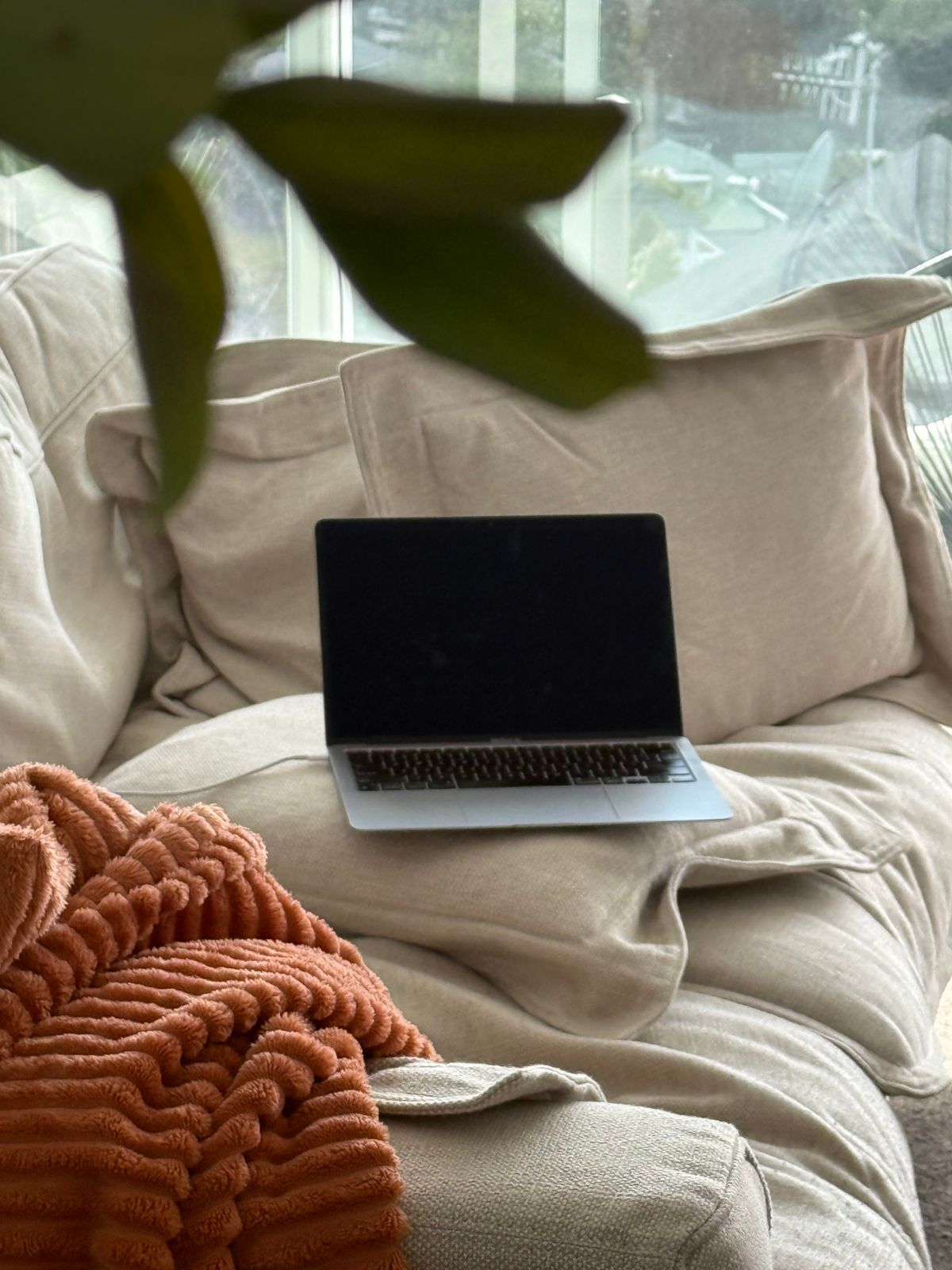Aesthetic, minimalist website design shown on a modern laptop nestled on a soft pillow, emphasizing beautiful structure and bespoke digital presence.