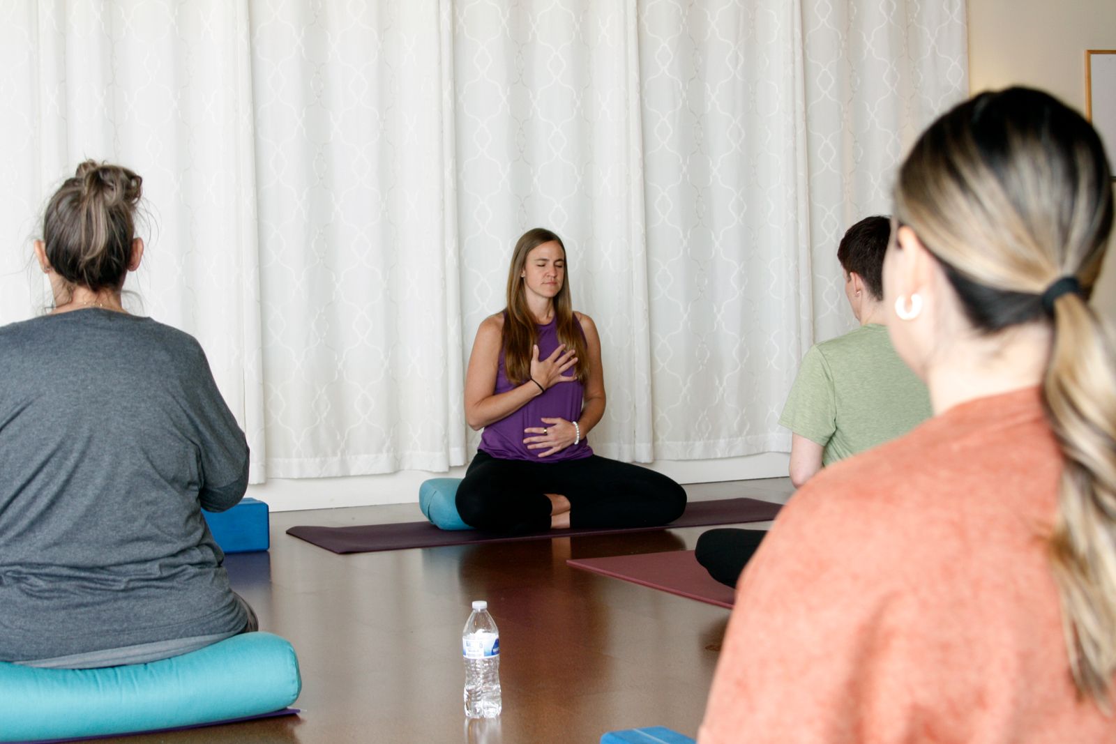 Students practicing gentle seated yoga at Sunflower Yoga Studio, connecting with breath and body in a calm, welcoming space.