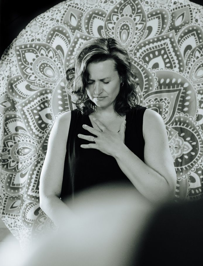 Emma,  a yoga teacher and holistic health coach, practicing interoception and resonance breath in connection to the heart