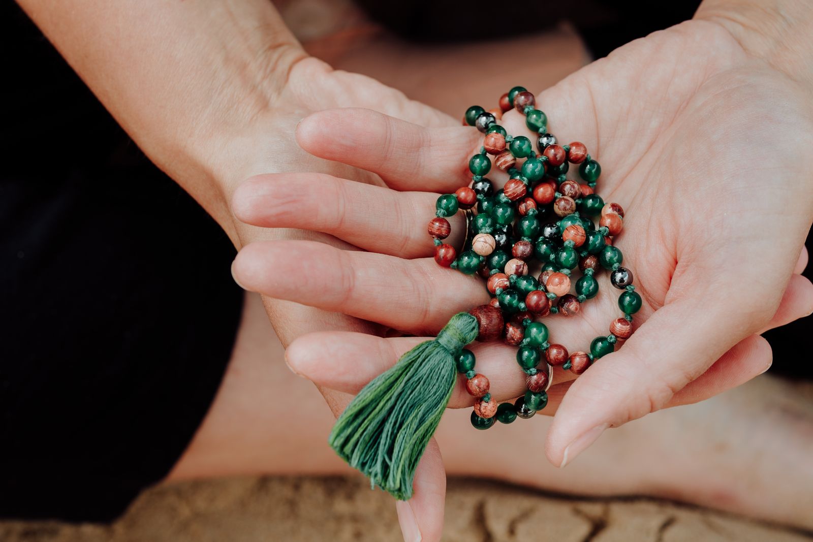 Emma, a holistic health coach, holding her meditation mala beads