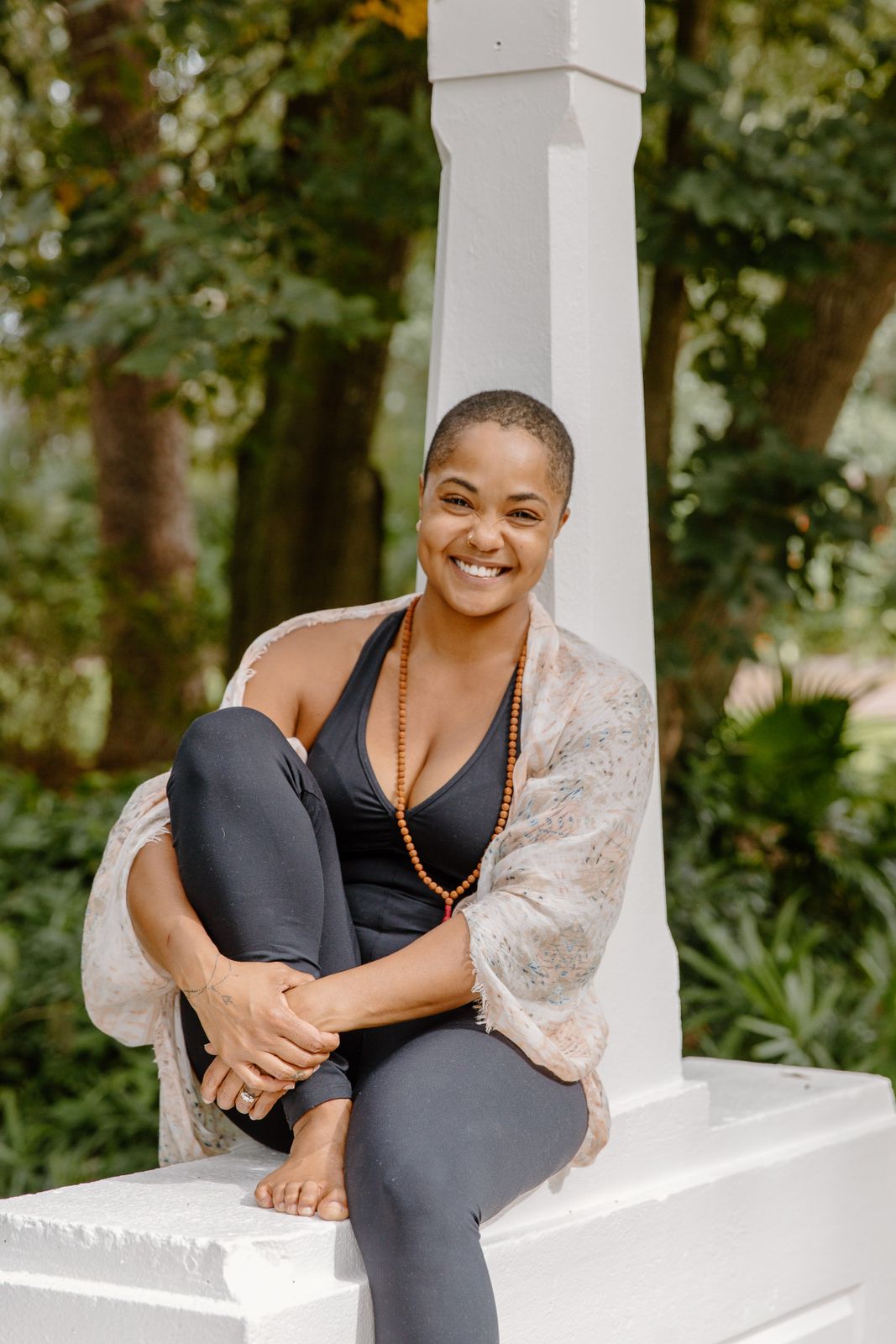 Asatta Jones is smiling at the camera, sitting with her back to a pillar 