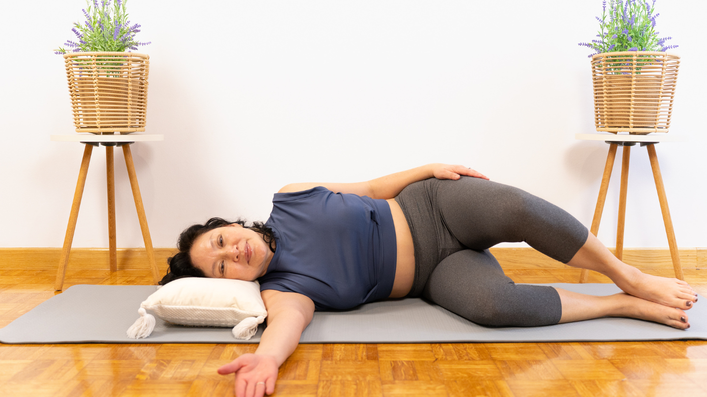 Woman practicing somatic yoga, doing a somatic exercise for vagus nerve stimulation and nervous system reset..