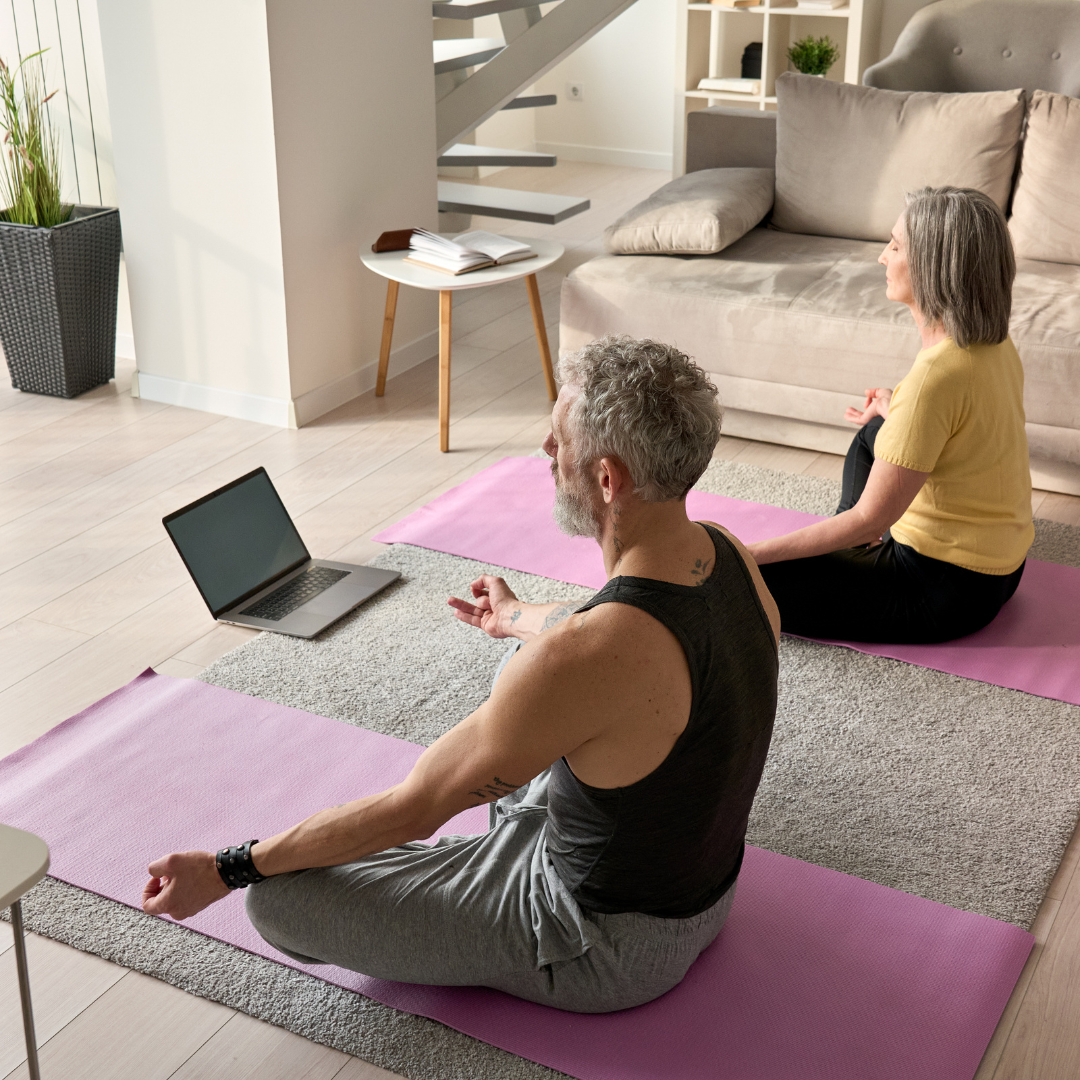 Man and woman over 50 performing yoga at home and confident.