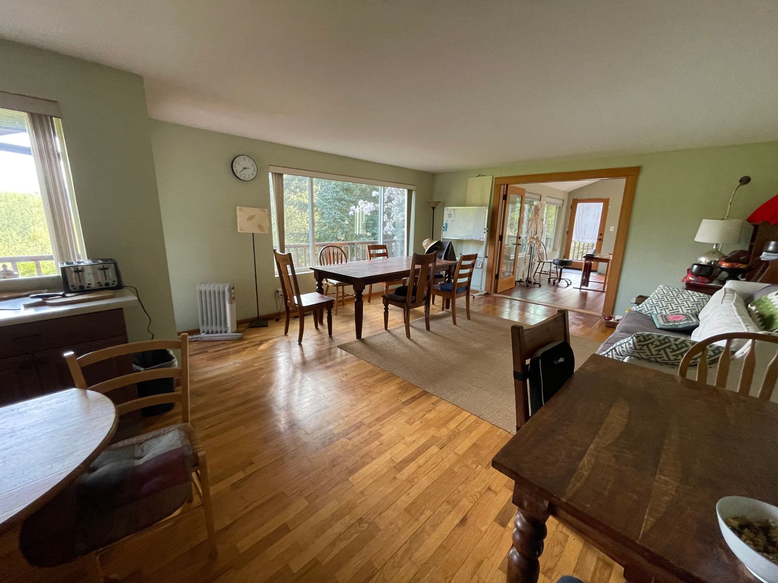 Communal space used for discussions and talks during retreats. Several tables with chairs and a sofa facing a window with a panoramic mountain view.