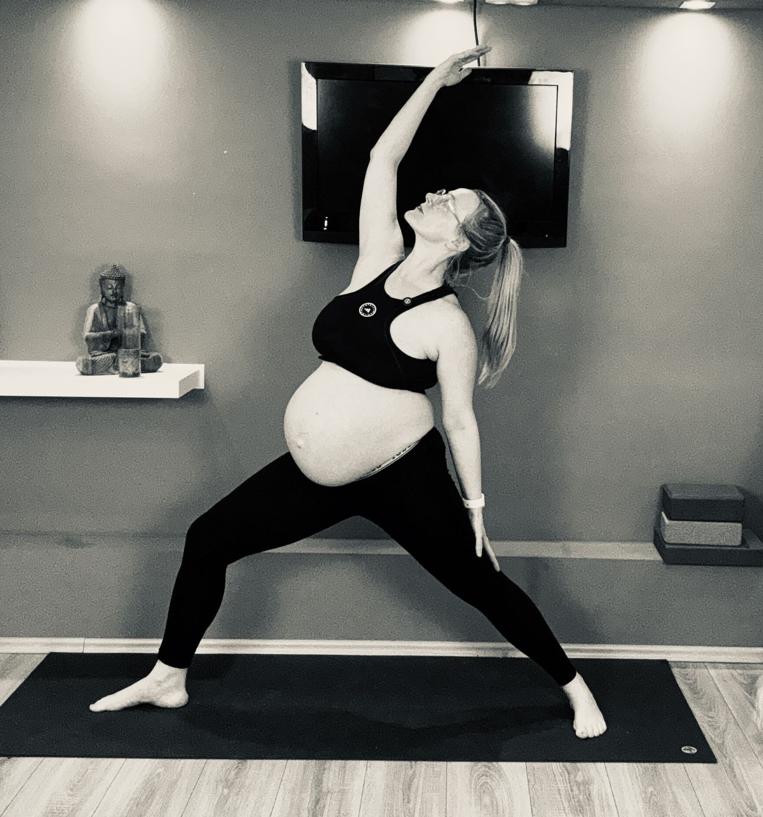Pregnant white woman in warrior yoga pose