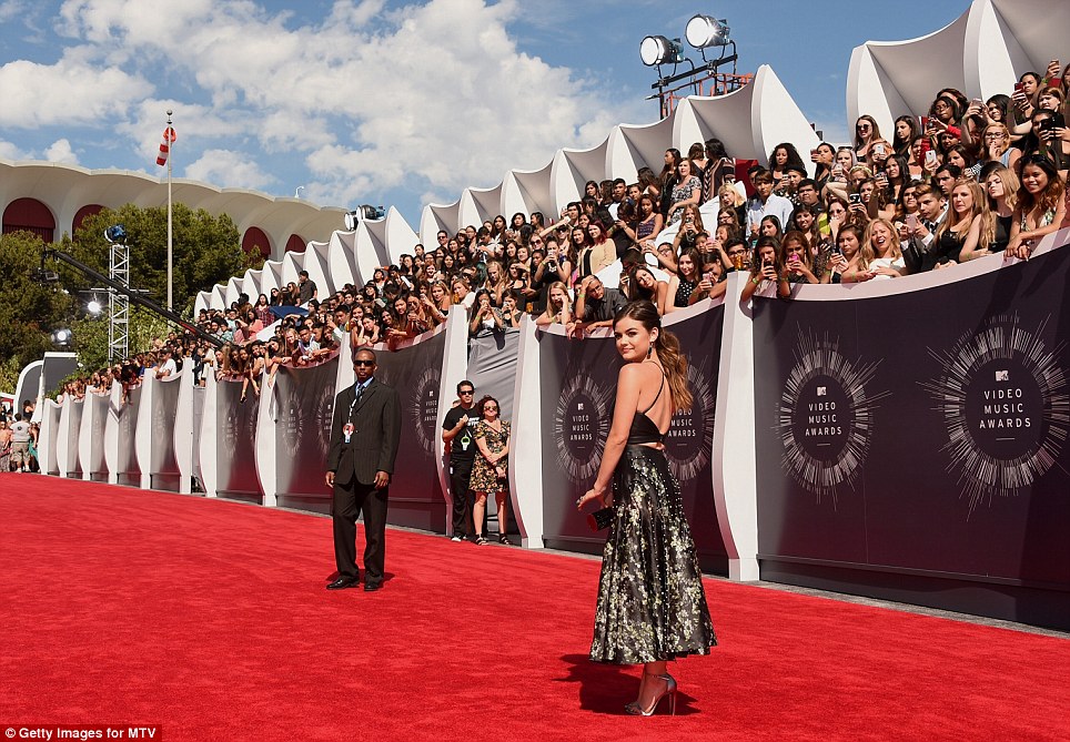 Darling of the carpet: Lucy Hale captured attention in a black short-cropped top teamed with a flaring black and pale-flowered skirt