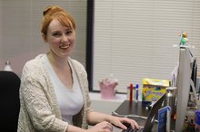 Eleri smiles from a desk