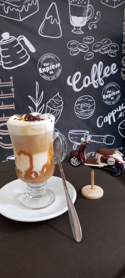 Un exquisito cortado manjar.
Un shot de café leche bien espumada y manjar a gusto adornado con chispas de colores.
