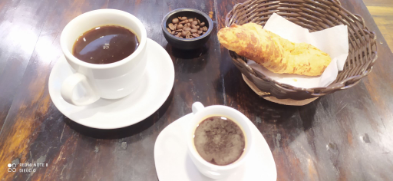 Un delicioso café expresó con amareto al lado de un buen americano.