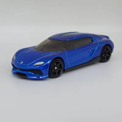 2026 Matchbox No. 107/125 is the 2021 Koenigsegg Gemera. Metalflake dark blue with a black interior and base is the late