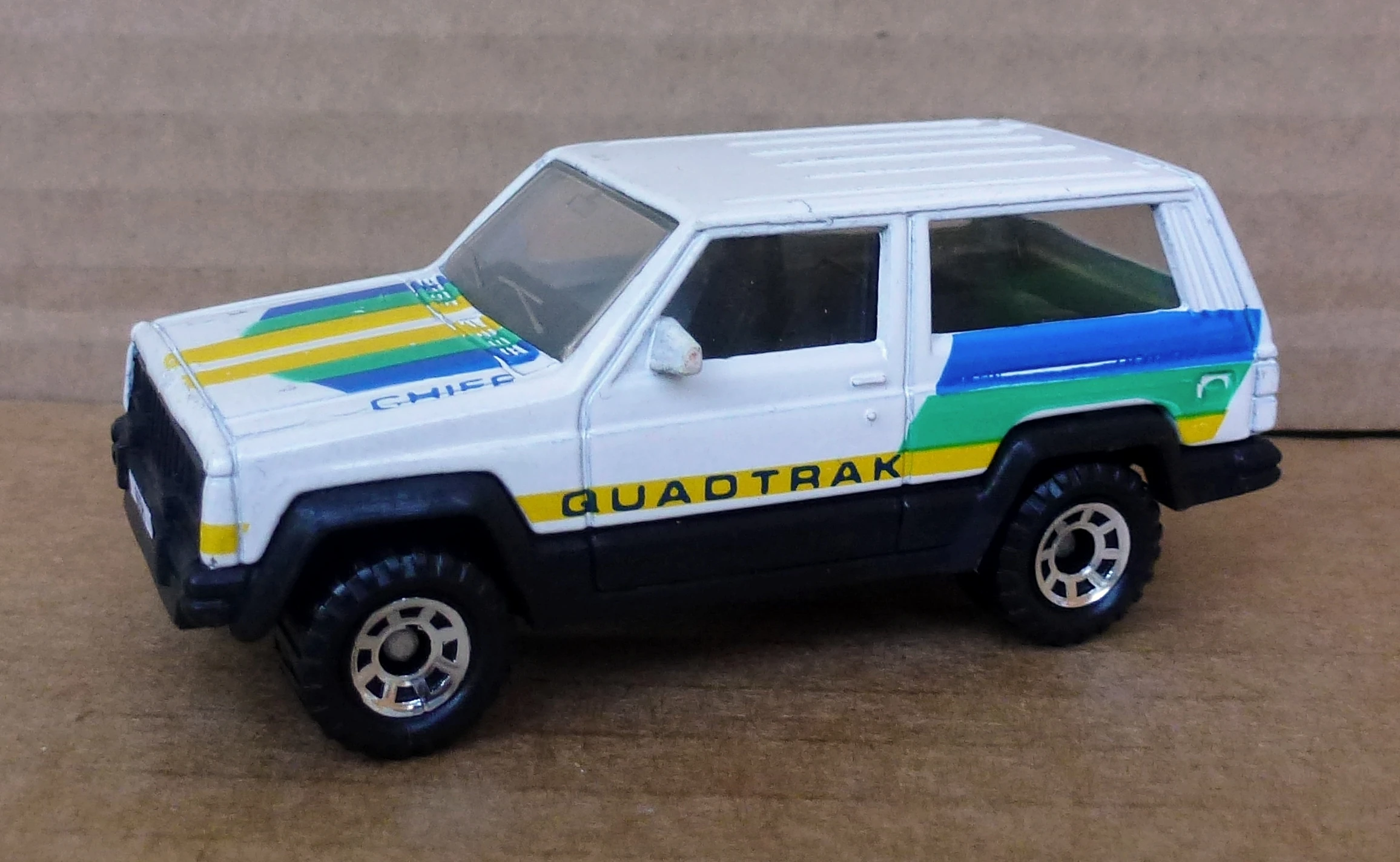 Jeep Cherokee (White, QUADTRAK; Blue, Green and Yellow stripes)