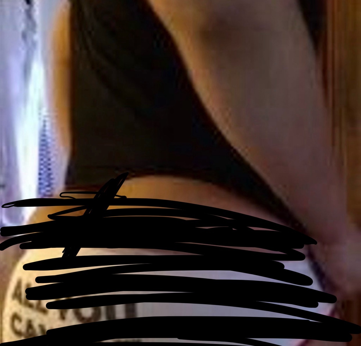 A close-up shot of a woman's lower back and buttocks, wearing white underwear with text on it.