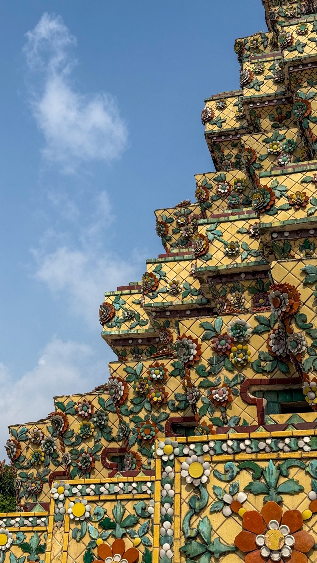 A close-up shot of a colorful, ornate temple structure against a clear blue sky. The intricate details of the building's design are highlighted.