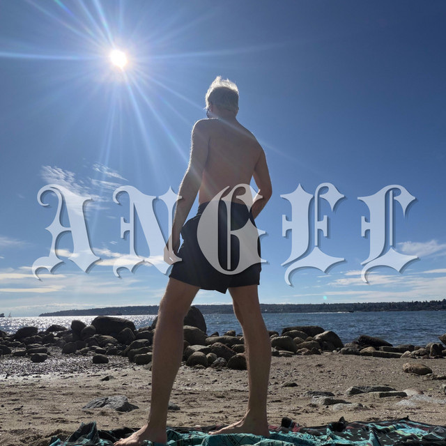 A shirtless man stands on a rocky beach, looking out at the ocean under a bright, sunny sky. The word "ANGEL" is superimposed over the image in a gothic font.