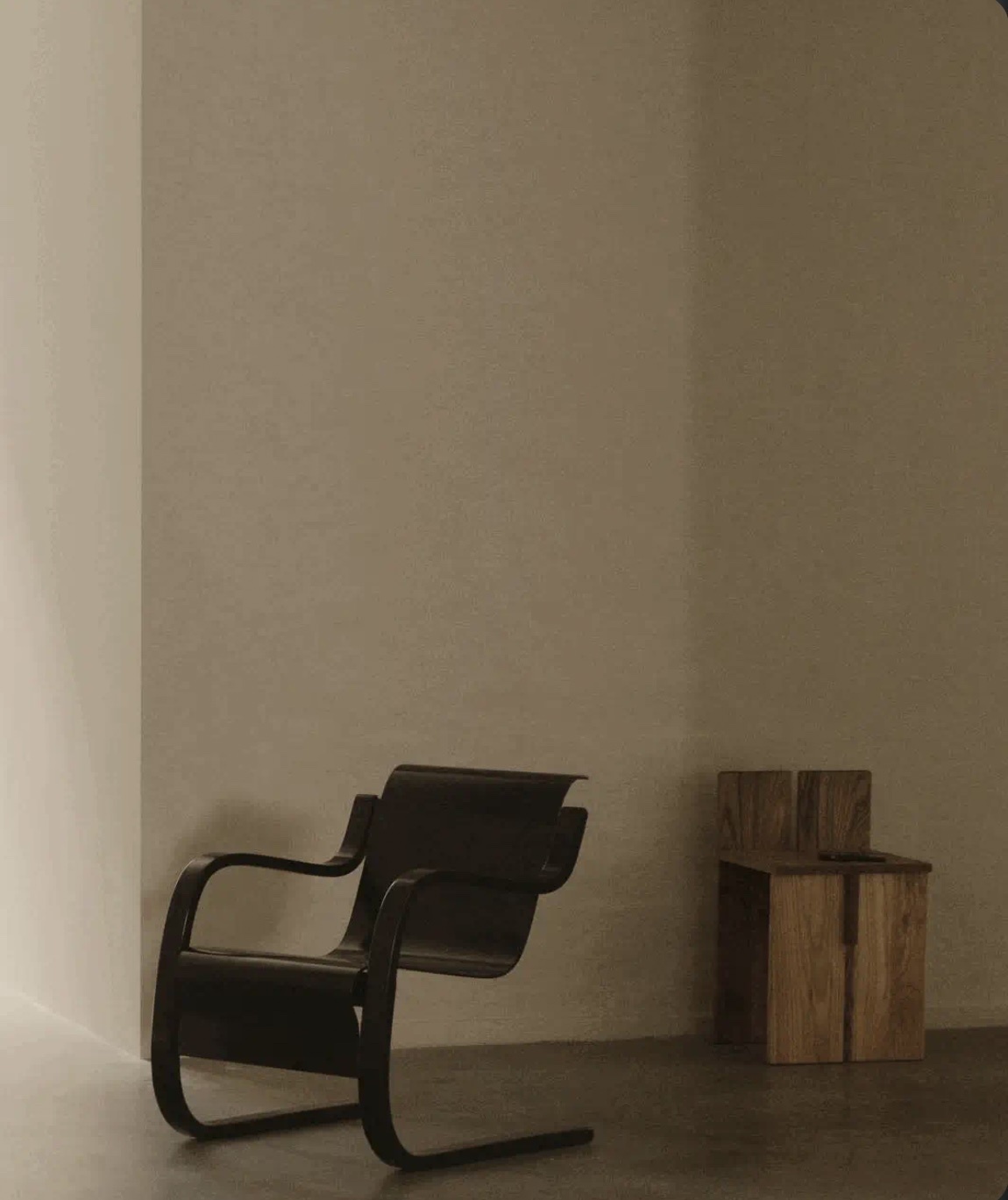 A minimalist interior featuring two chairs. The chairs are placed in a corner, with a neutral color palette.