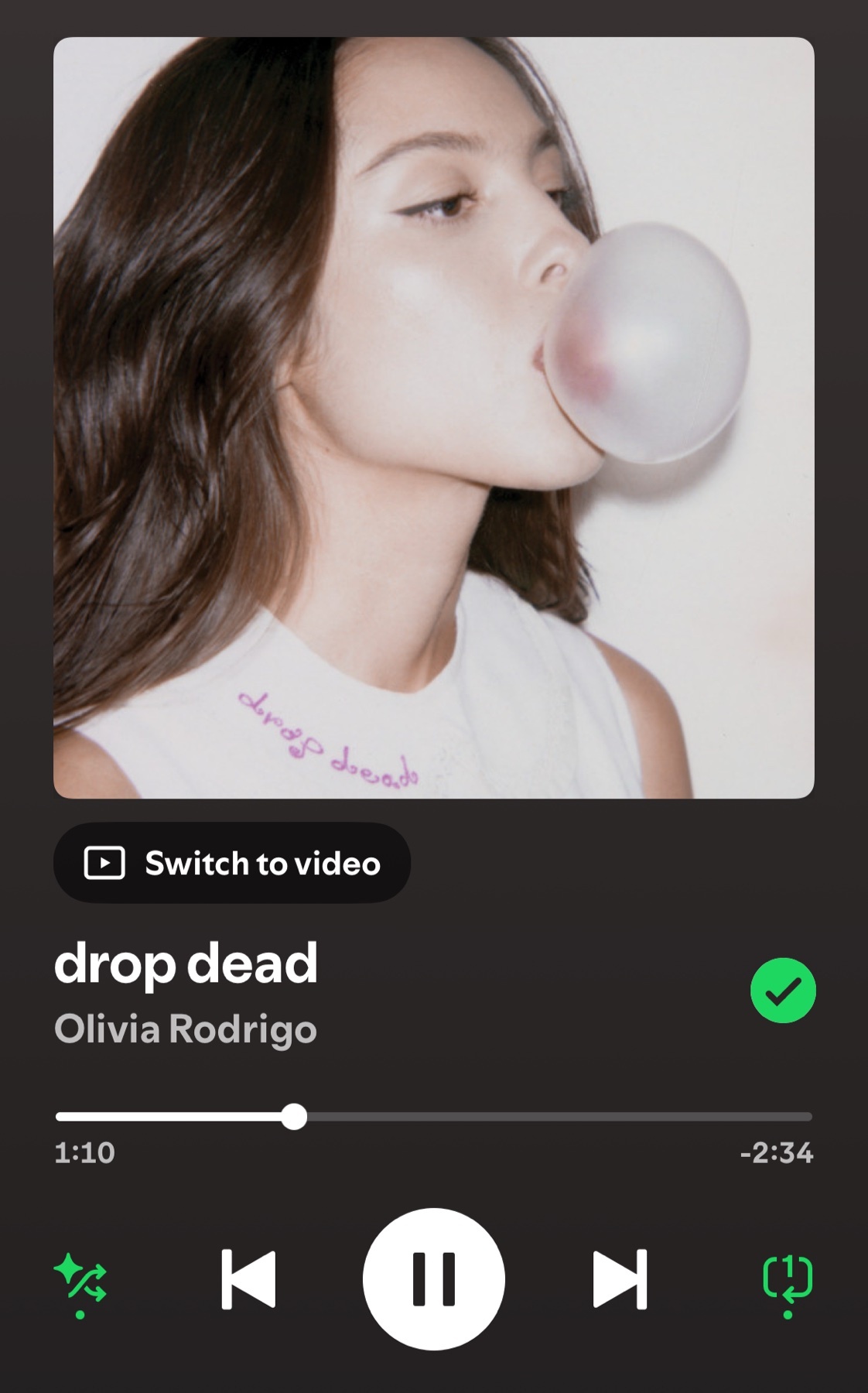 A close-up shot of a young woman blowing a large pink bubblegum bubble. The image is presented as album art for the song "drop dead" by Olivia Rodrigo.