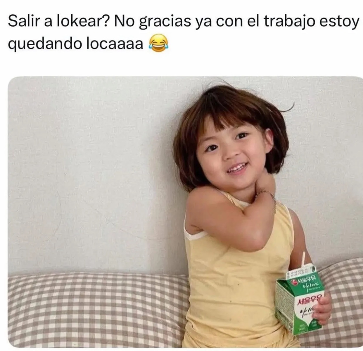 A young Asian girl with short, dark hair smiles and holds a carton of milk. The text above her reads 'Salir a lokear? No gracias ya con el trabajo estoy quedando locaaaa' which translates to 'Go out to party? No thanks, with work I'm already going cr
