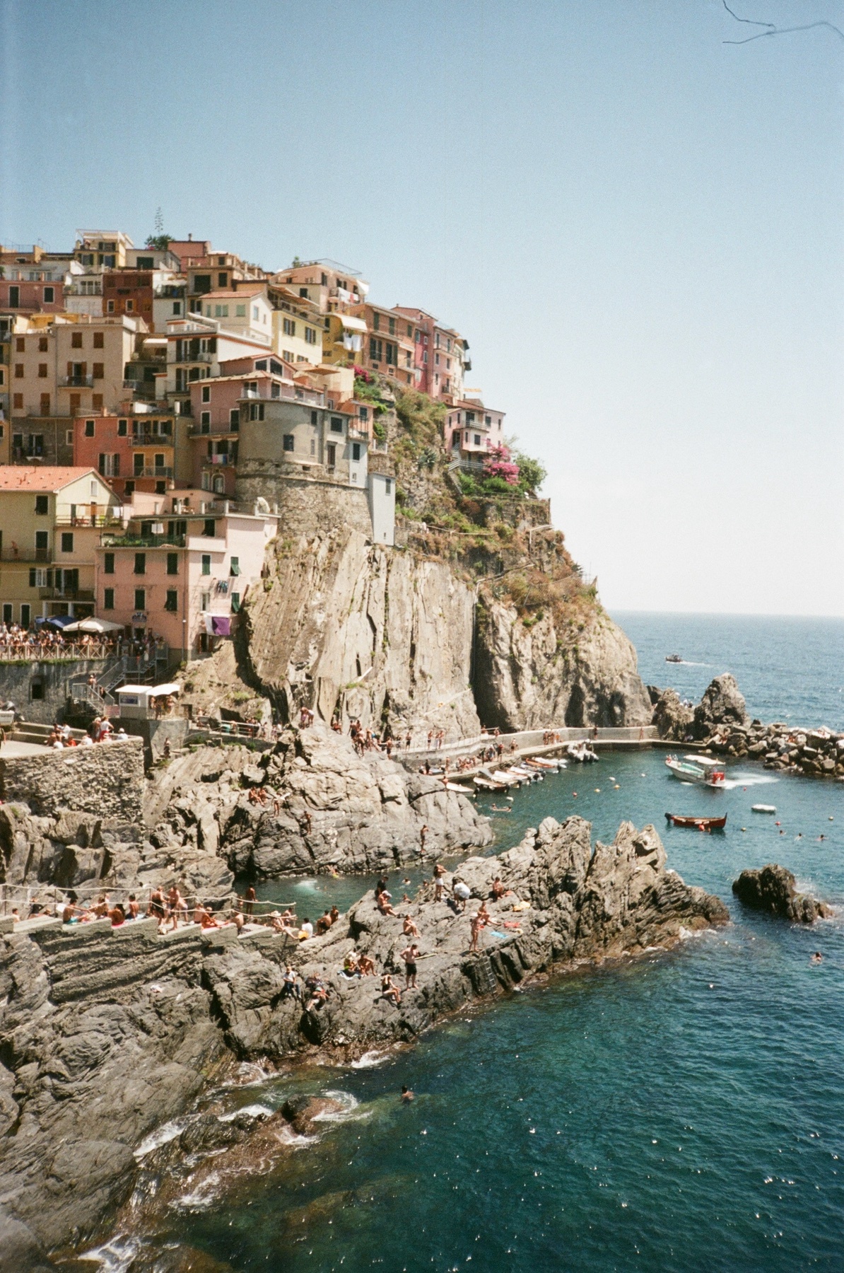A picturesque coastal town in Italy, with colorful buildings perched on a cliff overlooking the sea. The image captures the beauty of the architecture and the stunning natural surroundings.