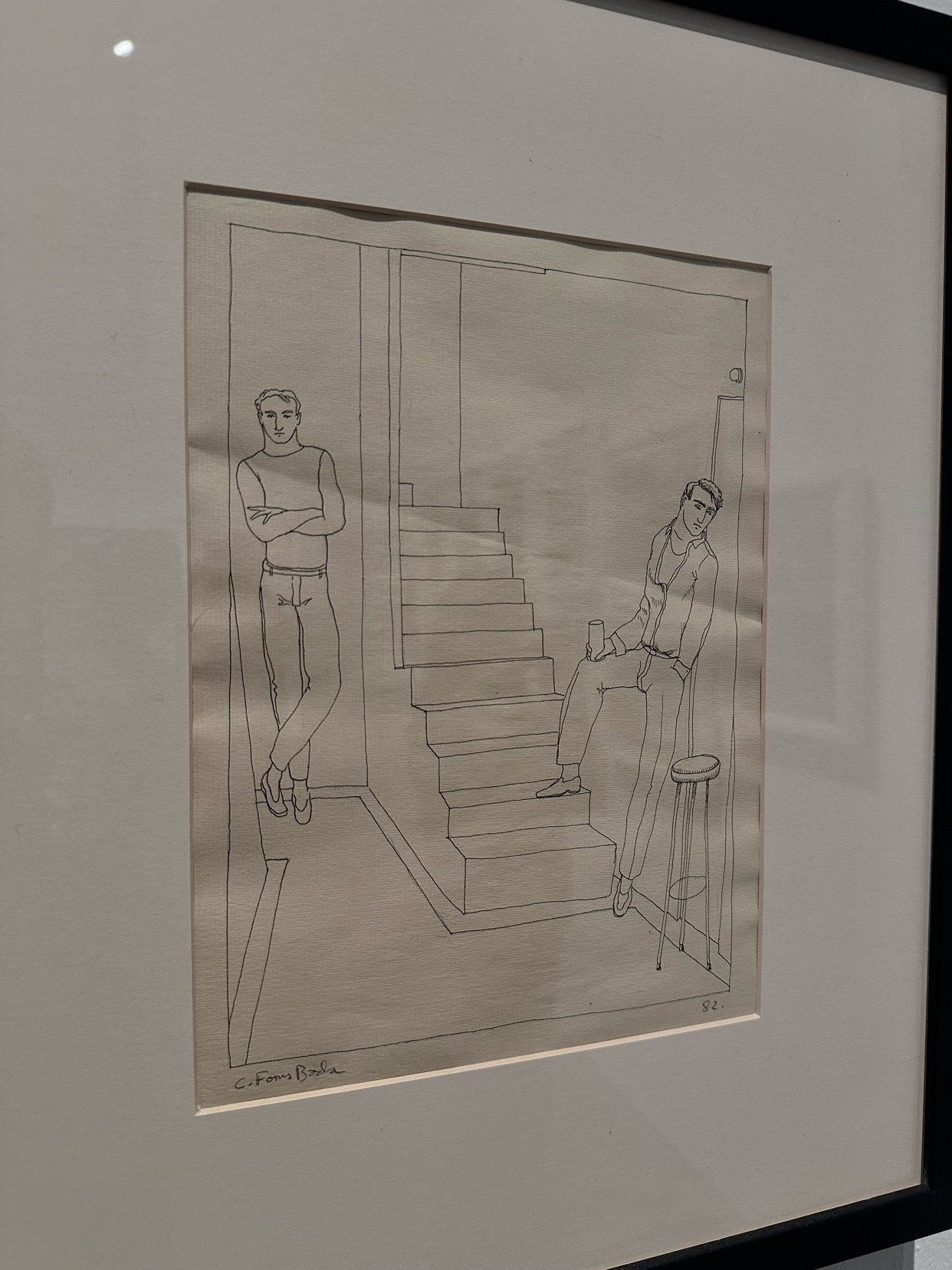 A framed line drawing depicts two men in an interior setting with a staircase. One man stands with his arms crossed, while the other sits on a stool holding a drink.