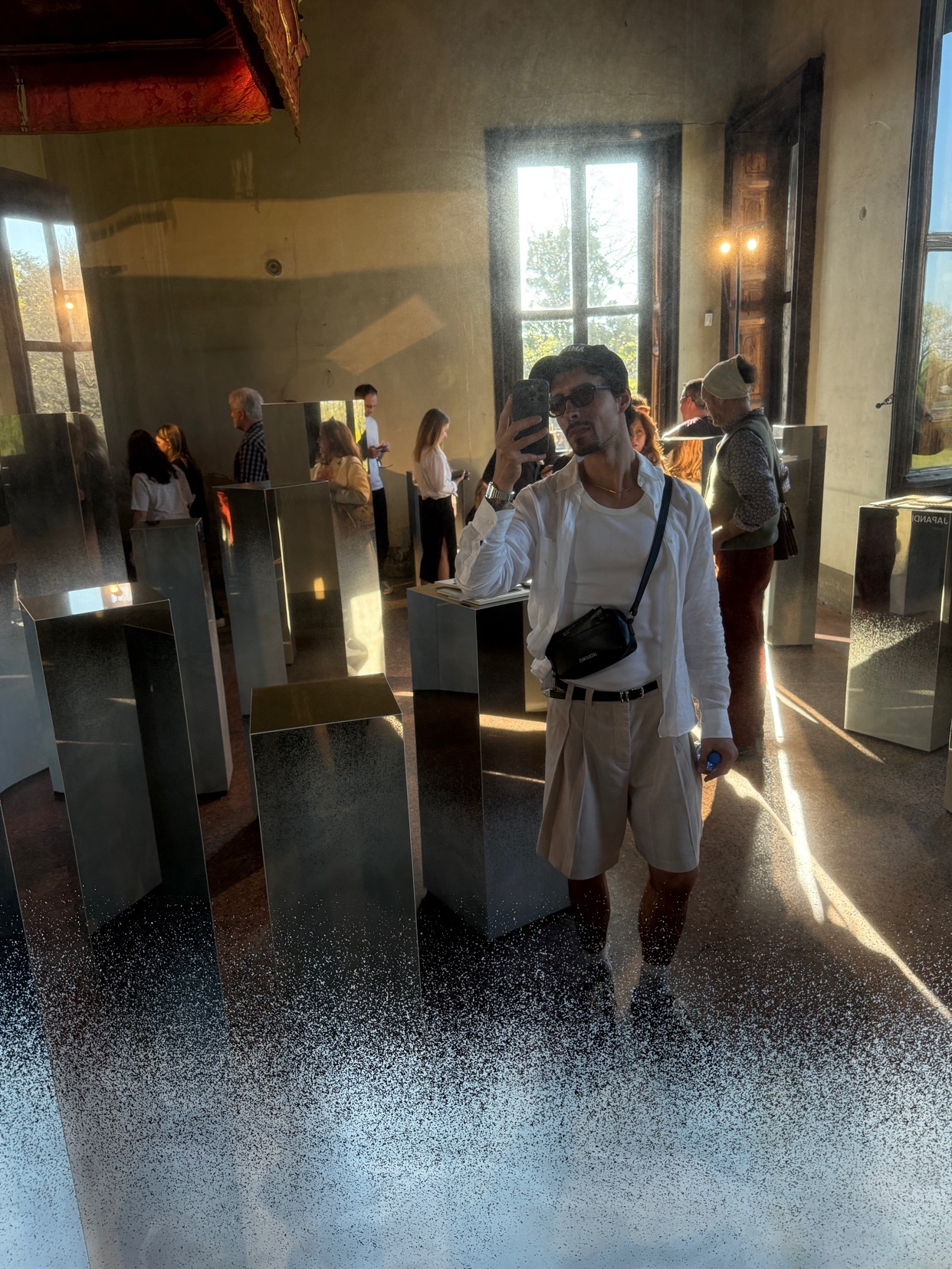 A man takes a selfie in a modern art installation. The photo showcases a unique design with mirrored surfaces.